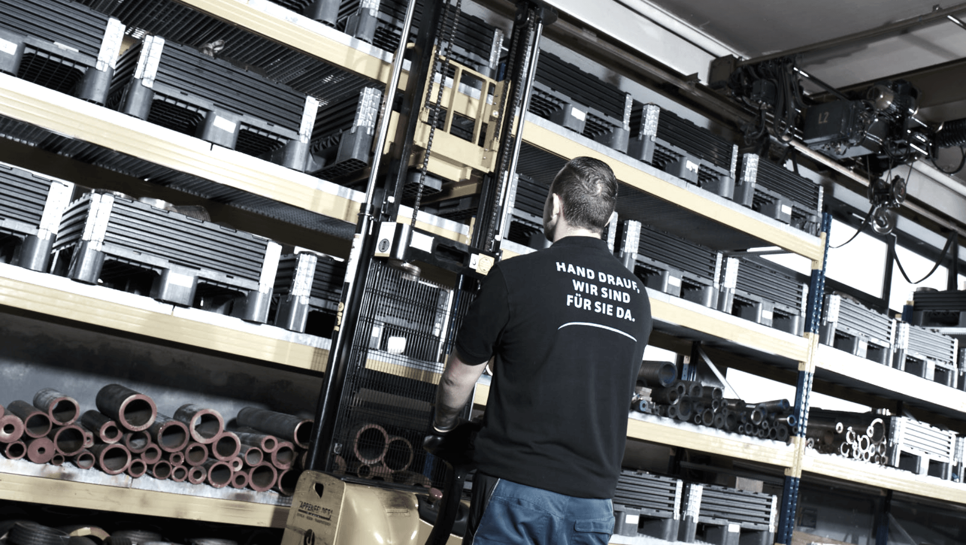 Man in a warehouse operating a yellow crane